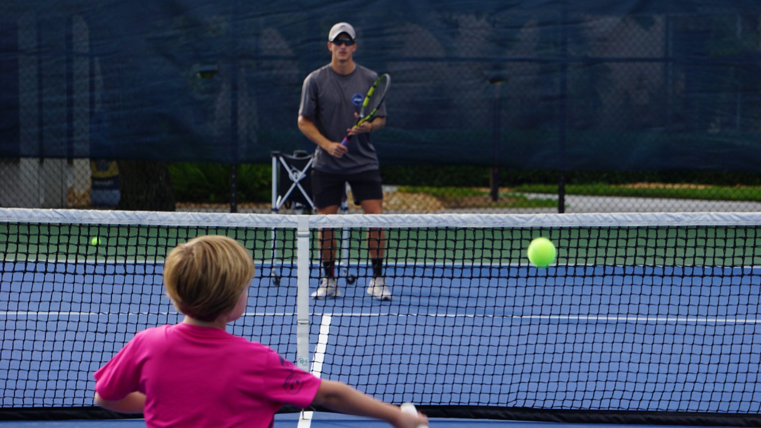 NMBA junior tennis player developing stroke mechanics and footwork during high-performance training in North Miami Beach