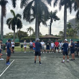 NMBA tennis players on court with palm trees North Miami Beach Academy South Florida