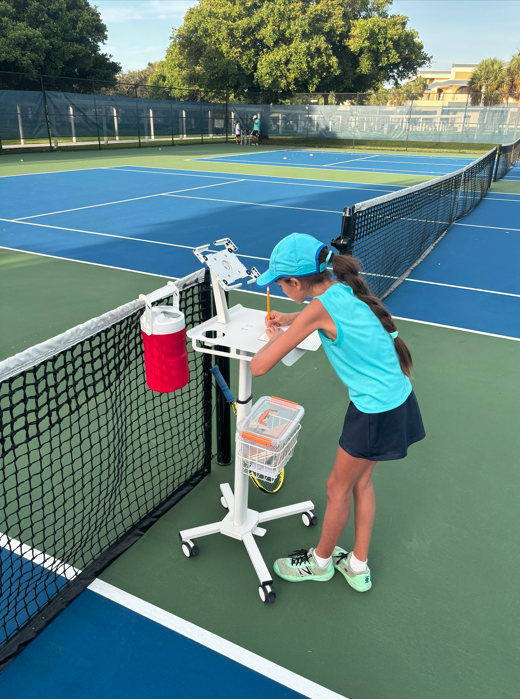NMBA junior tennis player training at net North Miami Beach Academy