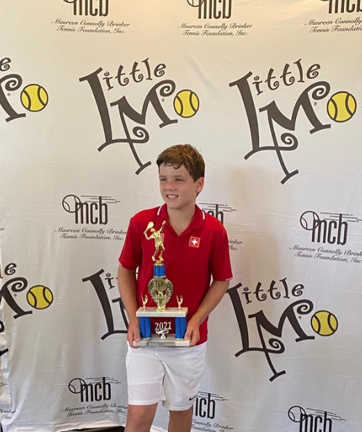 Luca Q. championship trophy moment — NMBA high-performance tennis academy
